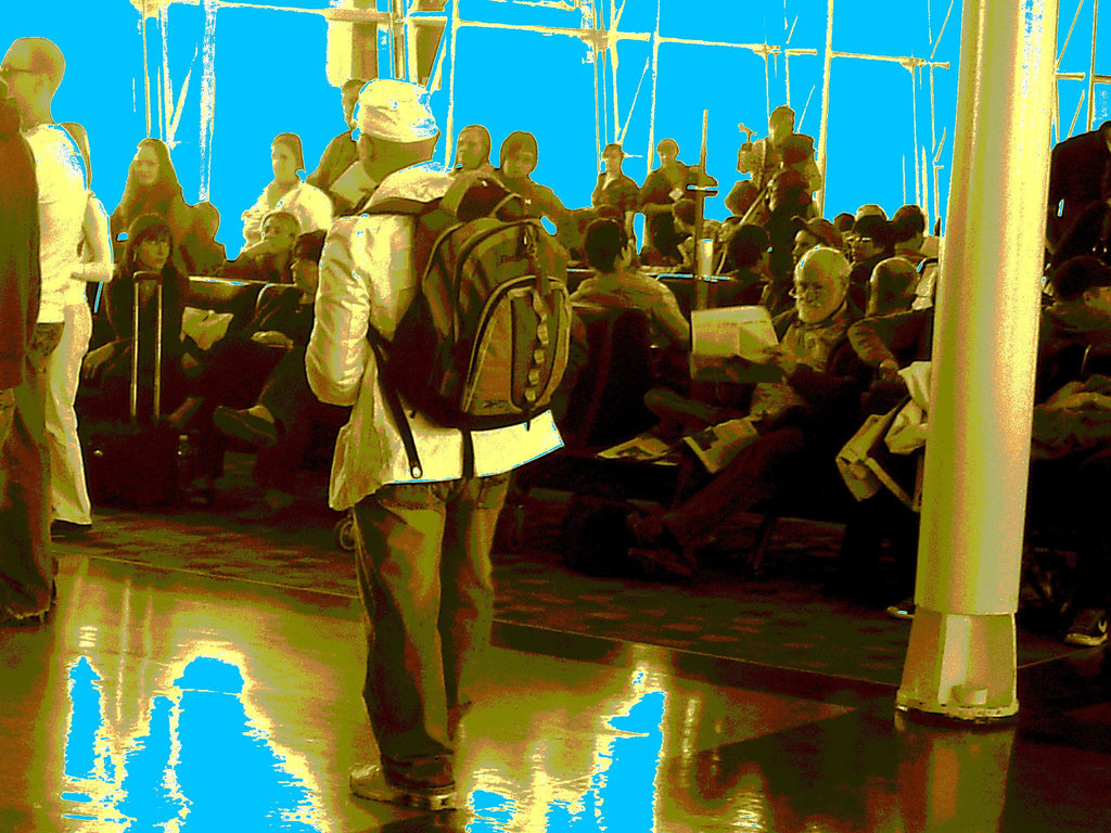 Homme mature à casque et sac à dos - Mature masculine hatter with his rucksack - PET Montreal airport - Avec le lecteur observateur / With the attentive reader -  Baskets et jeans. - Sepia postérisé avec bleu photofiltré.
